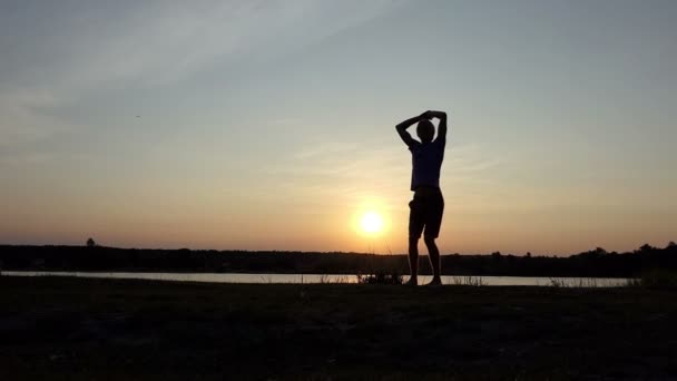 Giovane uomo salta con una ciotola campione al tramonto in slo-mo — Video Stock