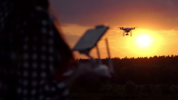 Smart Frau hält ein Panel, um ihre Drohne bei Sonnenuntergang in slo-mo verwalten — Stockvideo