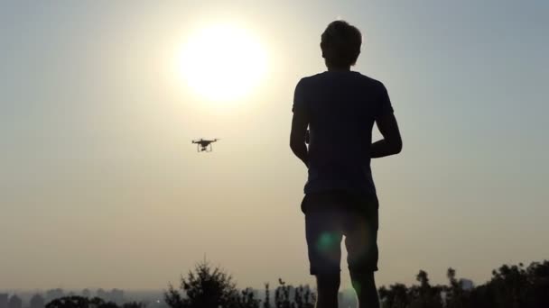 Νεαρός άνδρας του σύγχρονου drone με πάνελ λειτουργεί στο ηλιοβασίλεμα σε slo-mo — Αρχείο Βίντεο