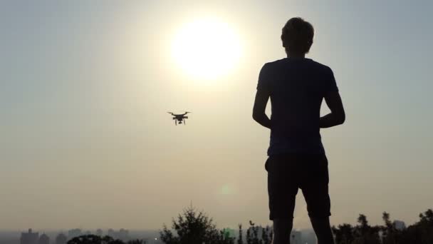 Homem loiro opera seu drone voador com painel ao pôr do sol em slo-mo — Vídeo de Stock