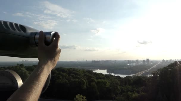 Jovem usa um vidro espião em um deck de observação sobre o Dnipro — Vídeo de Stock