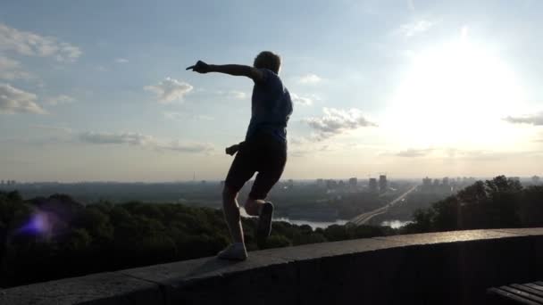 Sportive άνδρας χορεύει σε ένα κατάστρωμα παρατήρησης στο Κίεβο στο slo-mo — Αρχείο Βίντεο