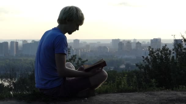 Dreaming człowiek czyta książkę na taras widokowy w Kijowie w slo-mo — Wideo stockowe