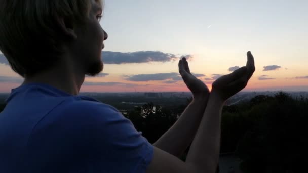 Arty άνθρωπος κρατά τον ήλιο στα χέρια του το ηλιοβασίλεμα στο Κίεβο στο slo-mo — Αρχείο Βίντεο