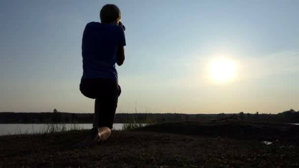 Fotoğrafçı bir göl kenarında bir arty sunpath slo-mo gün batımında vuruyor — Stok video