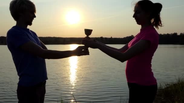 Young man hands over his winner bowl to a young woman in slo-mo — Stock Video