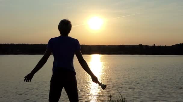 Hravý muž stojí a drží vítěz mísa na jezero v slo-mo — Stock video