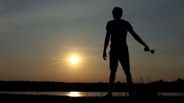 Homme heureux se tient debout et soulève un bol gagnant à un lac à Xo@-@ mo — Video