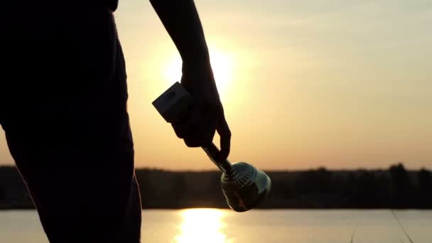 Männliche Hand hält eine Meisterschale an einem See in Slo-mo — Stockvideo