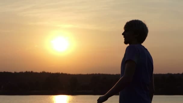 Jeune homme soulève son bol gagnant joyeusement à un lac à Xo@-@ mo — Video
