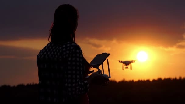 Ładne kobiety działa z panelem do sterowania drone o zachodzie słońca — Wideo stockowe