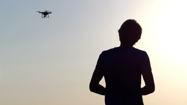 Smart man arbeitet mit einem Quadracopter-Panel bei Sonnenuntergang in slo-mo — Stockvideo