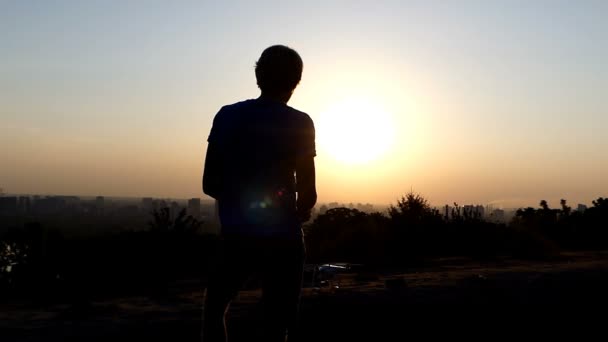 Hombre rubio controla el vuelo de un dron en una bonita puesta de sol — Vídeos de Stock
