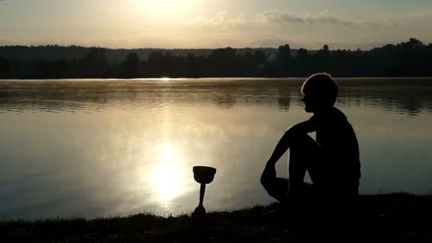 Mutiger Mann blickt auf seine Meisterschale an einem See in Slo-mo — Stockvideo