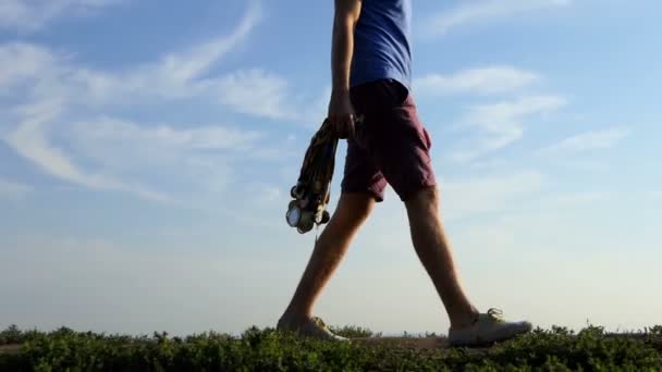 Giovane uomo cammina con un sacco di medaglie su una corsia in estate — Video Stock