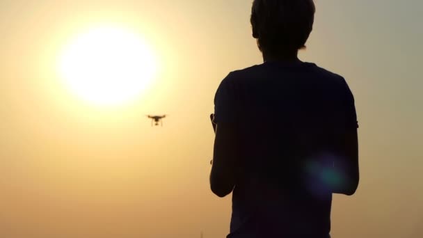 Ευτυχισμένος άνθρωπος χρησιμοποιεί ένα νέο ιπτάμενο quadracopter στο ηλιοβασίλεμα σε slo-mo — Αρχείο Βίντεο