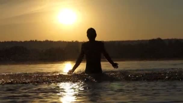 Блондин поднимает озерную воду, чтобы развлечься на закате в сло-мо — стоковое видео