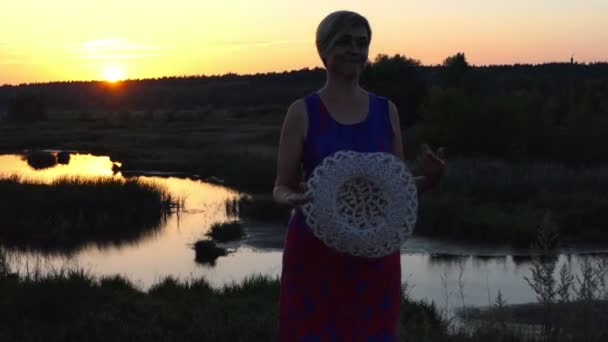 Mulher alegre dança com um chapéu de palha ao pôr do sol — Vídeo de Stock