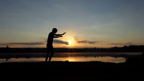 Sportif adam elindeki slo-mo bir göl kıyısında duruyor — Stok video