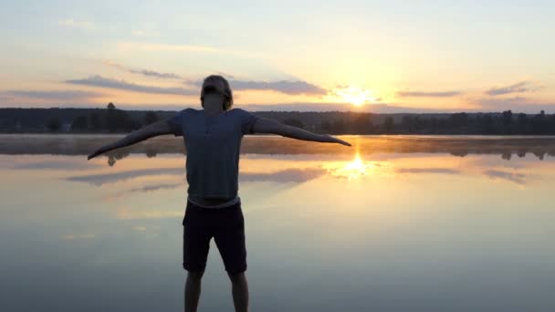 Hombre Arty mantiene las manos a un lado y mira el atardecer en slo-mo — Vídeos de Stock