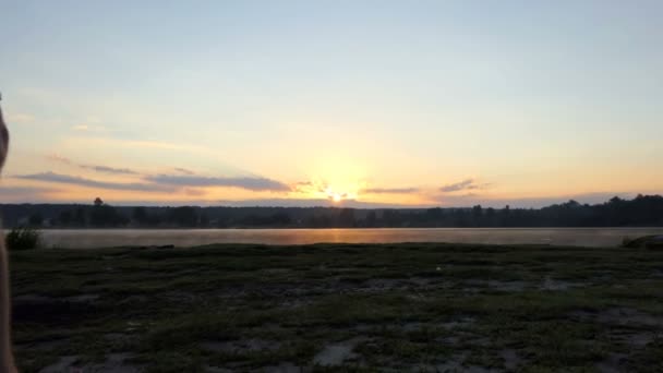 Hombre alegre corre a un lago del bosque en una espléndida puesta de sol en slo-mo — Vídeo de stock