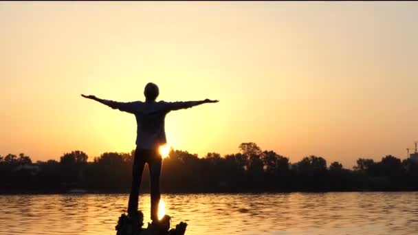 L'uomo onirico sta sulle radici di un albero su una riva del lago — Video Stock