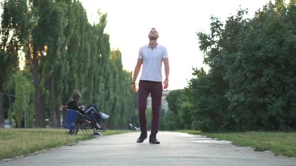 Adamın biri parkta yürüyor, ağır çekimde hayatın tadını çıkarıyor. — Stok video