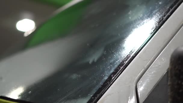 Чистка стекла автомобиля ночью на заправке со старой губкой и палкой . — стоковое видео