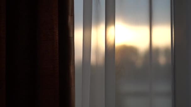 Pôr do sol fora da janela em que cortinas brancas - câmera lenta . — Vídeo de Stock