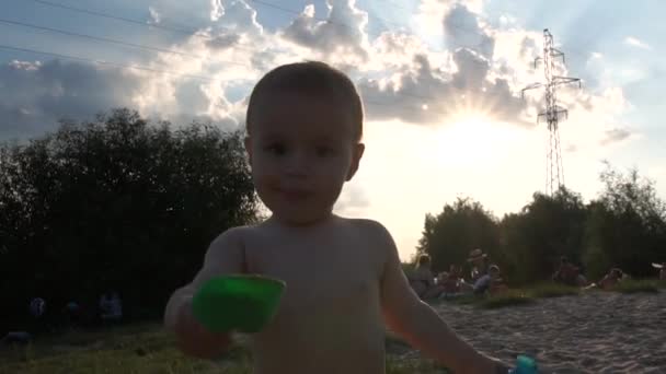 Spiaggia vicino alle linee elettriche - Bambino seduto a giocare con una pala al rallentatore . — Video Stock