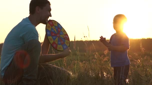 Papa hält Darts in den Händen und gibt seinem Sohn fünf - Zeitlupe, Sonnenuntergang. — Stockvideo