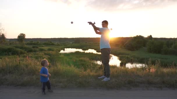 Papa toont circus trucs aan zijn zoon, hij kijkt in verbazing — Stockvideo