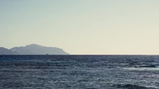 Vlnící se vlny s horou v pozadí v Rudém moři — Stock video