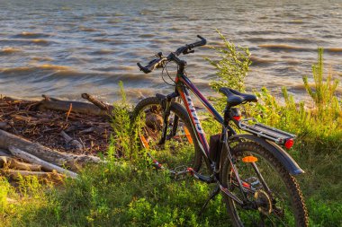 Nehir Ob, Berdsk, Novosibirsk Oblastı, Sibirya, Rusya - 6 Temmuz 2017: günbatımında Nehri'nin kıyısında bisiklet