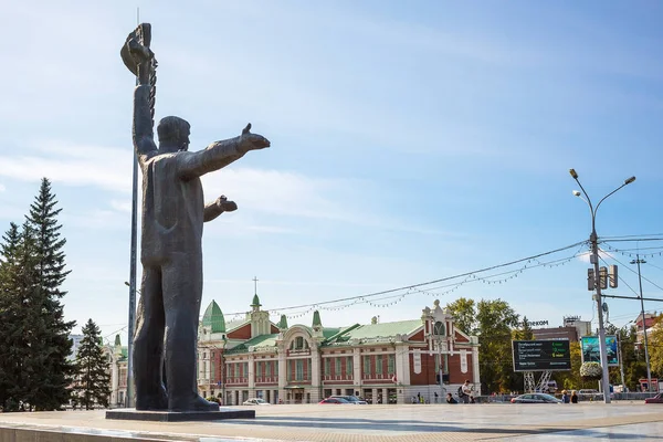 En ung man med en ficklampa och flickan med öron på Lenin fyrkantig skulpturala sammansättning — Stockfoto