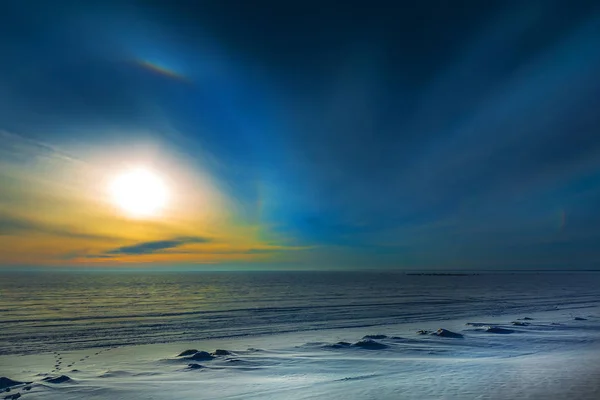 La puesta de sol de invierno y halo solar sobre el río congelado. Siberia Fotos De Stock Sin Royalties Gratis