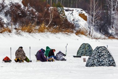 Razdelnaya river, Berdsk, Novosibirsk region, Western Siberia, Russia-February 23, 2020: Fishermen with winter tents on a snow-covered river