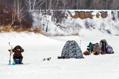 Razdelnaya river, Berdsk, Novosibirsk region, Western Siberia, Russia-February 23, 2020: Fishermen with winter tents on a snow-covered river