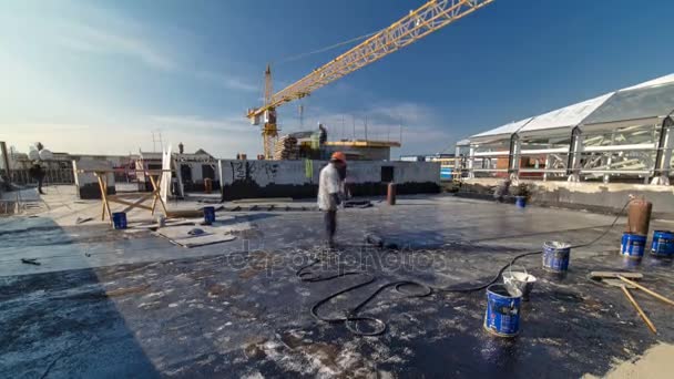 Dakdekker dakbedekking installeren voelde met verwarming en smelten van bitumen roll door fakkel op vlam tijdens dak Reparatie timelapse — Stockvideo