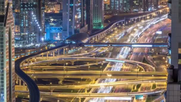 Luchtfoto van de snelweg afslag met verkeer timelapse in Dubai, Verenigde Arabische Emiraten, 's nachts. Beroemde Sheikh Zayed road in Dubai centrum. — Stockvideo