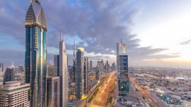Gece timelapse doğal Dubai şehir mimarisi günler. Işıklandırılmış gökdelenler ve trafik ile Şeyh Zayed Yolu üzerinde Üstten Görünüm.