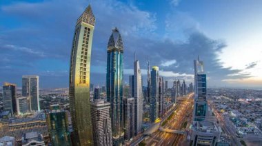 Gece timelapse doğal Dubai şehir mimarisi günler. Işıklandırılmış gökdelenler ve trafik ile Şeyh Zayed Yolu üzerinde Üstten Görünüm.