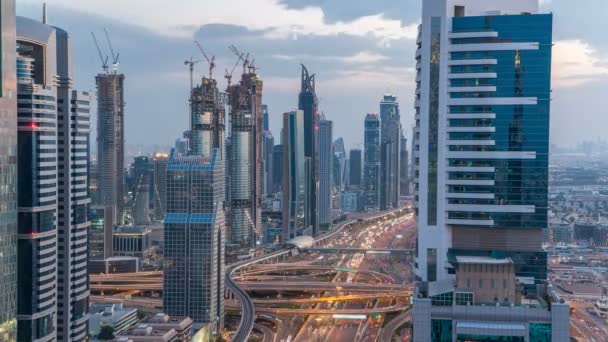 Scène Dubaï architecture du centre-ville jour à nuit timelapse. Vue de dessus sur la route Sheikh Zayed avec des gratte-ciel éclairés et la circulation . — Video