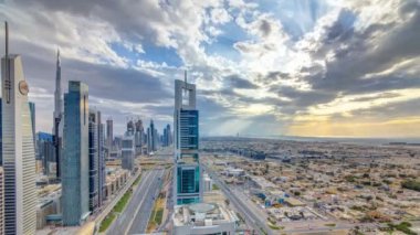 Dubai gökdelenleri, gün batımı akşam vakti. Dubai Metro İstasyonu ve Şeyh Zayed Yolu üzerindeki trafik