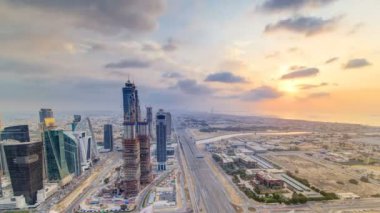 Dubai iş hangarı kuleleri, gün batımı zaman ayarlı. Bazı gökdelenlerin çatı manzarası ve inşaat halindeki yeni kuleler.