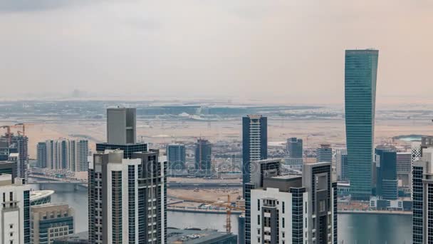 Dubais ビジネス湾は塔の夕刻を撮影する前に。いくつかの高層ビルや建設中の新しいタワー屋上ビュー. — ストック動画