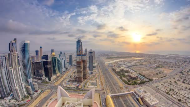 Dubai tours de baie d'affaires avec coucher du soleil timelapse. Vue sur le toit de certains gratte-ciel et de nouvelles tours en construction. — Video