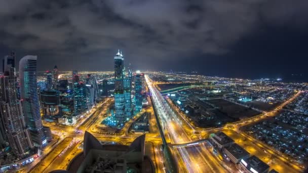 Dubai öböl üzleti tornyok a timelapse éjjel világít. Tetőtéri nézetet felhőkarcolók és új torony építés alatt. — Stock videók
