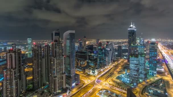 Dubai torres de la bahía de negocios iluminadas por la noche timelapse. Vista de la azotea de algunos rascacielos y nuevas torres en construcción . — Vídeos de Stock