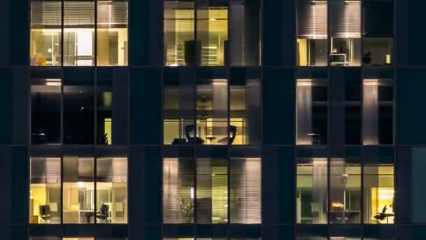 Ventana del edificio de varios pisos de iluminación de vidrio y acero y personas dentro de timelapse — Vídeo de stock